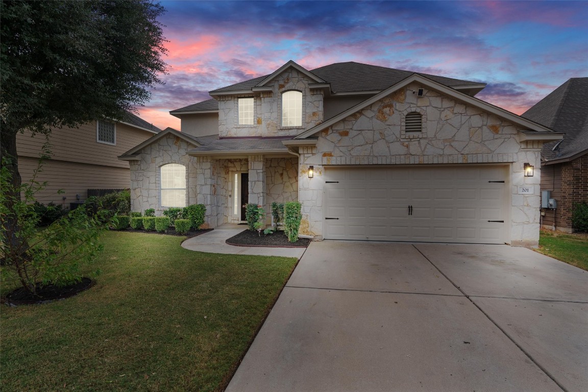 a front view of a house with yard and green space