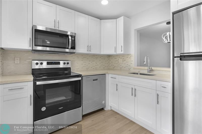 a kitchen with white cabinets stainless steel appliances and sink