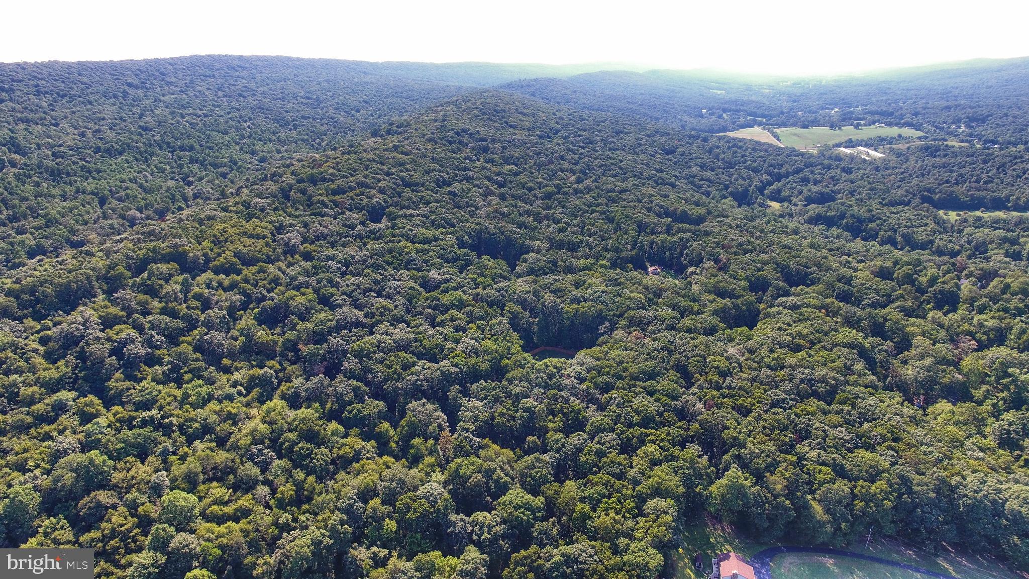 an aerial view of house with yard and mountain view in back