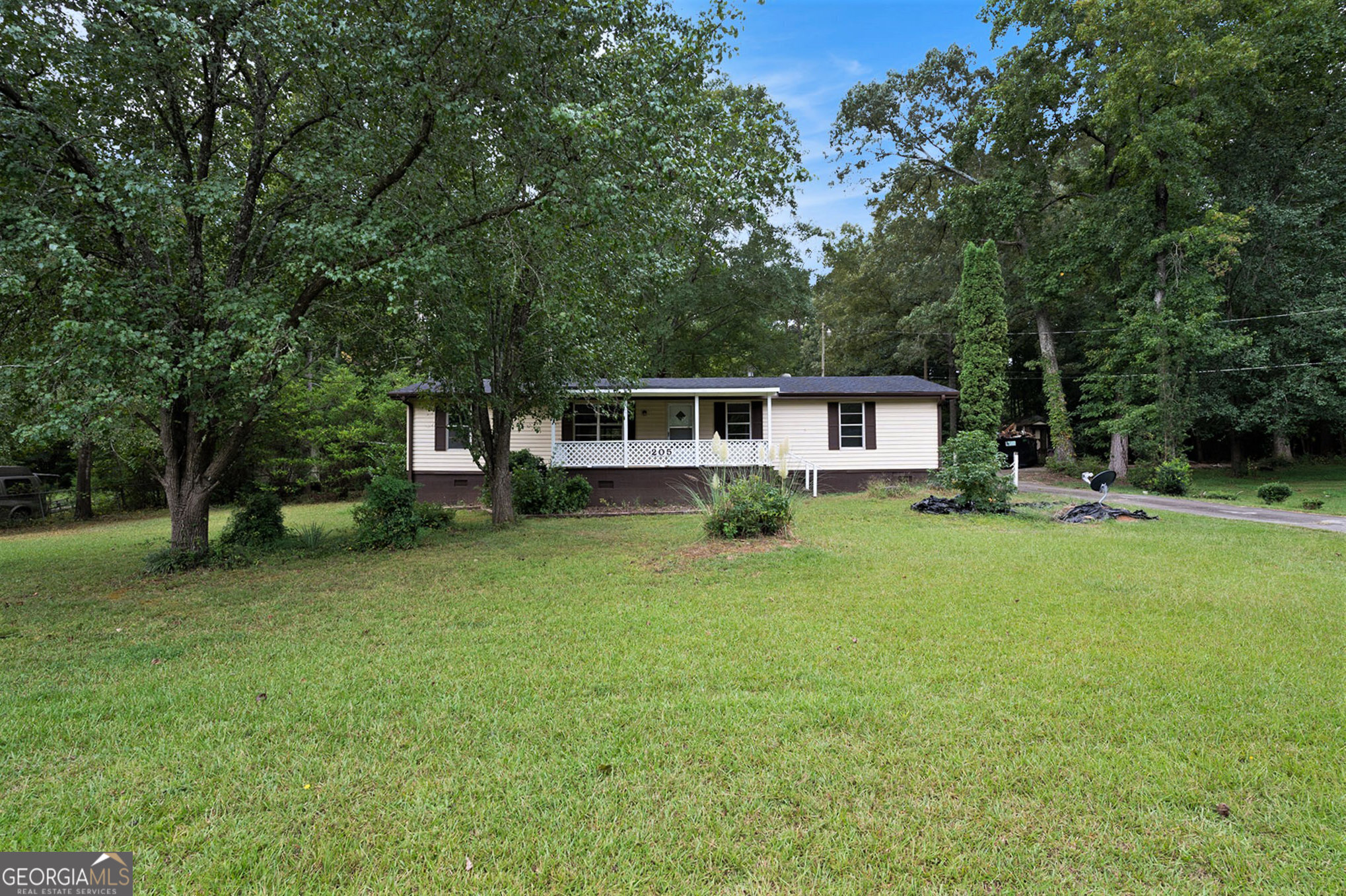 a front view of a house with a garden and trees