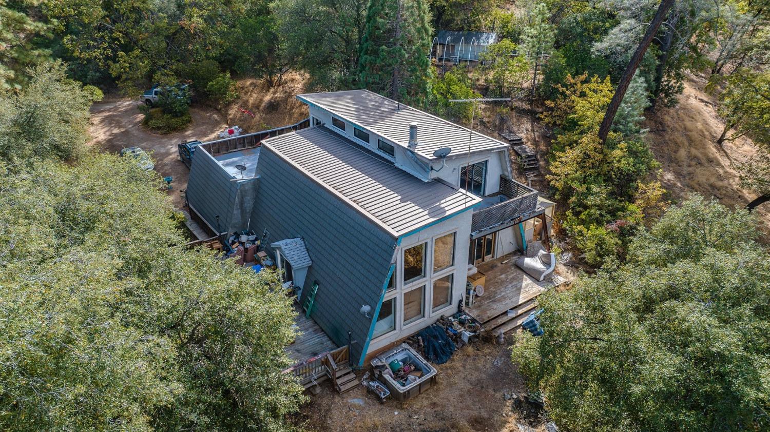 an aerial view of a house with a yard and large trees