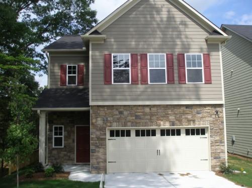 a front view of a house with glass windows and garage