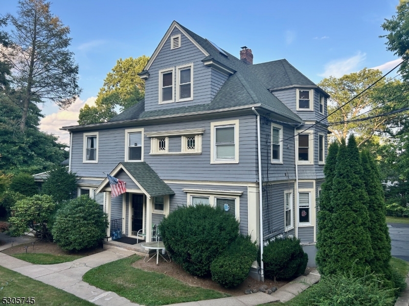 a front view of a house with a yard and trees