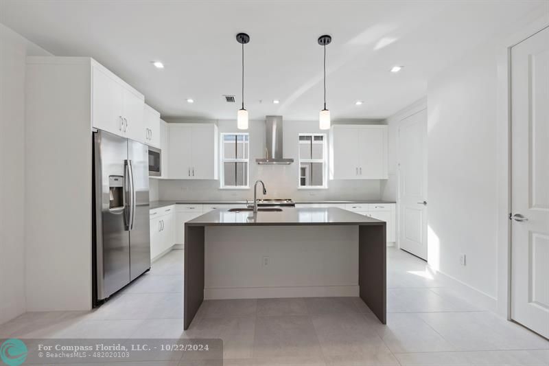 a kitchen with stainless steel appliances a sink stove and refrigerator