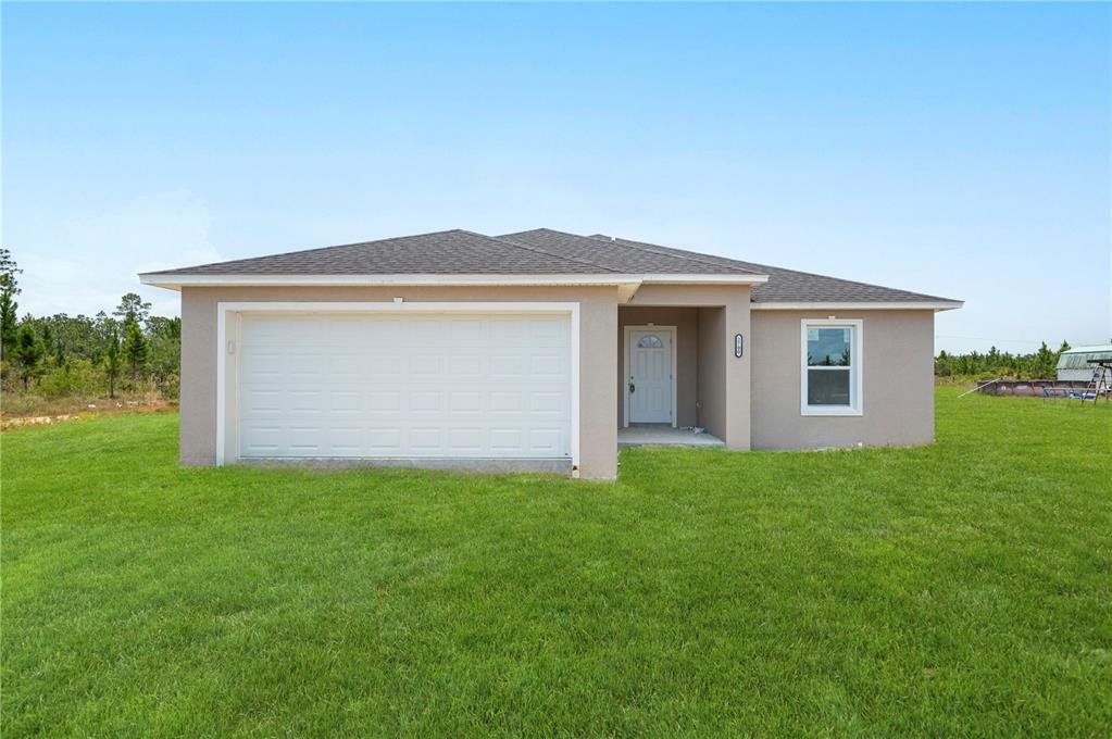 a front view of house with yard and green space