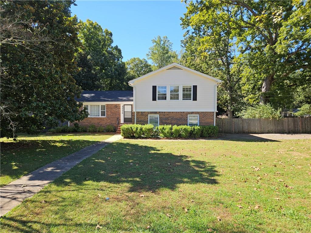 a front view of a house with yard and green space