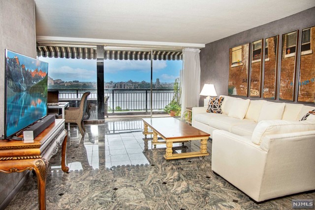 a living room with furniture a floor to ceiling window and floor to ceiling window