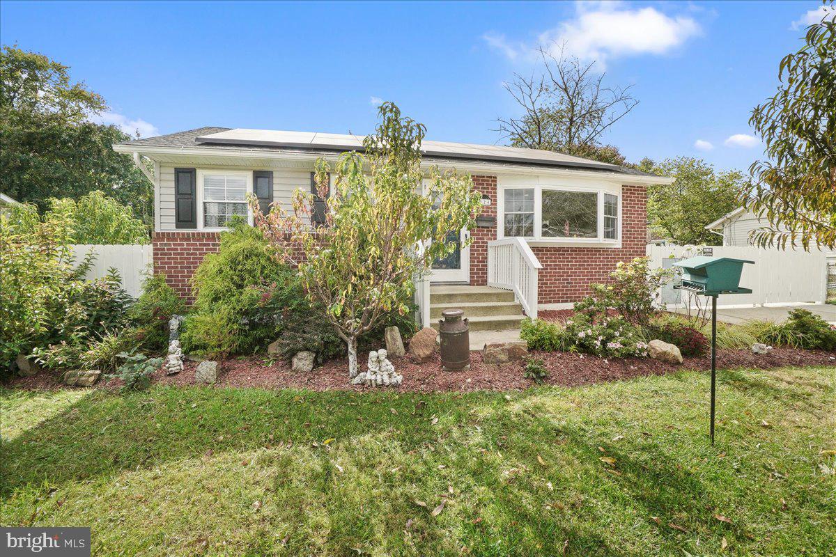 a front view of a house with a yard and potted plants