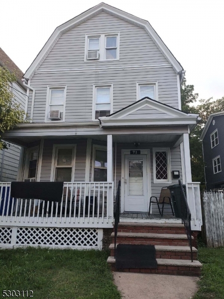 a view of a house with a deck and furniture