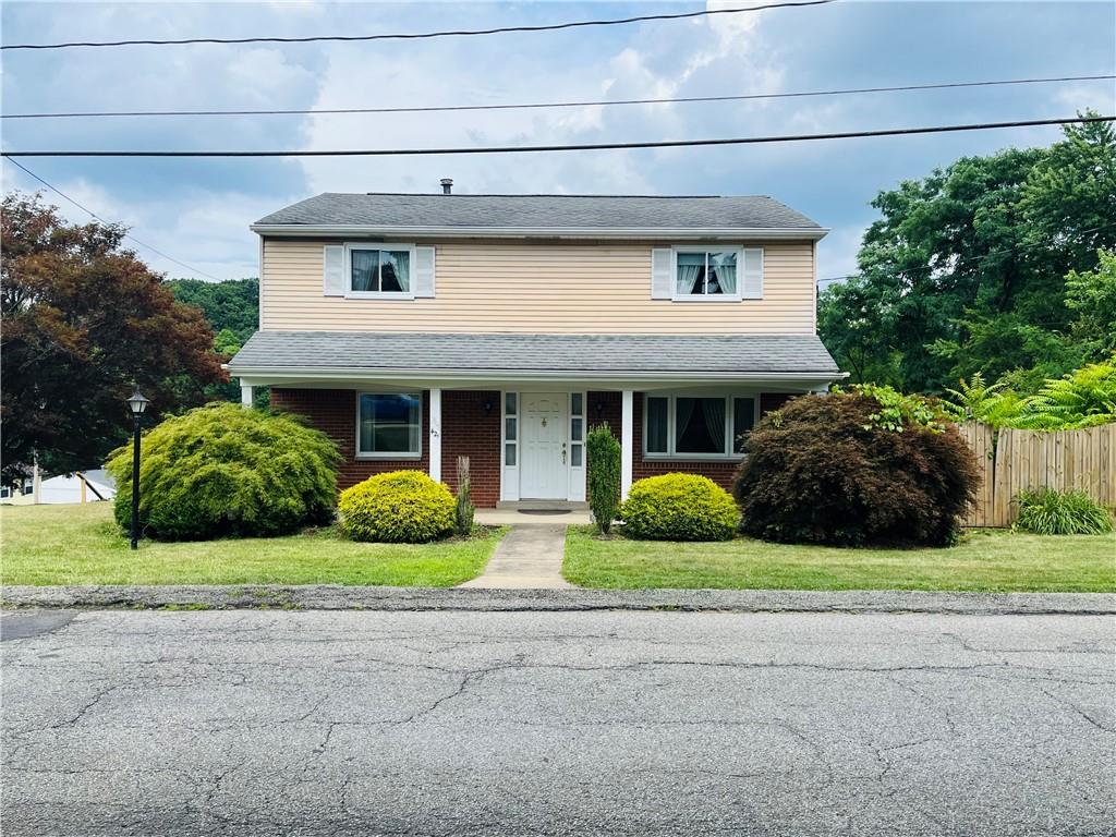 a view of front a house with yard and outdoor seating