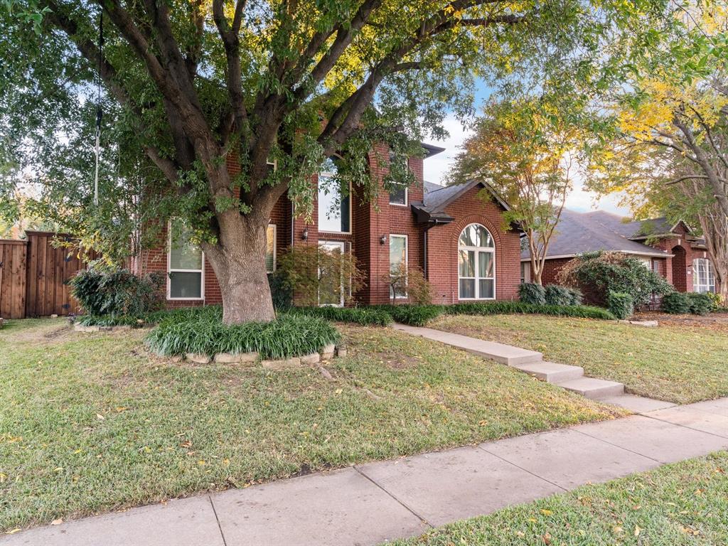 a brick house with trees in front of it