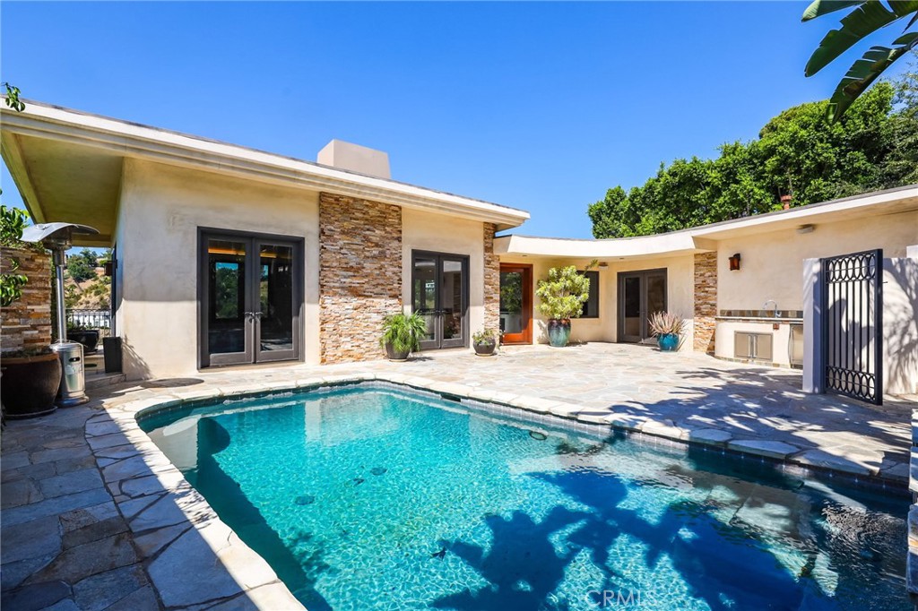 a view of a house with swimming pool and sitting area