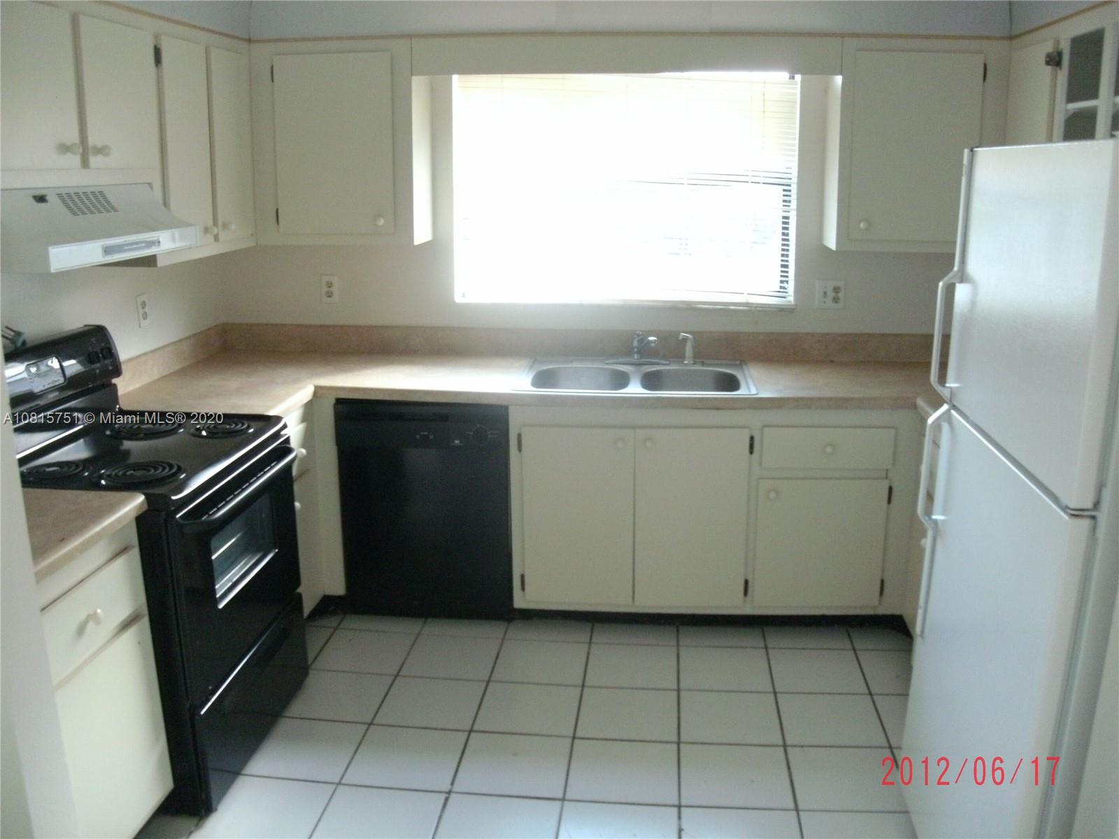 a kitchen with a sink a stove and cabinets