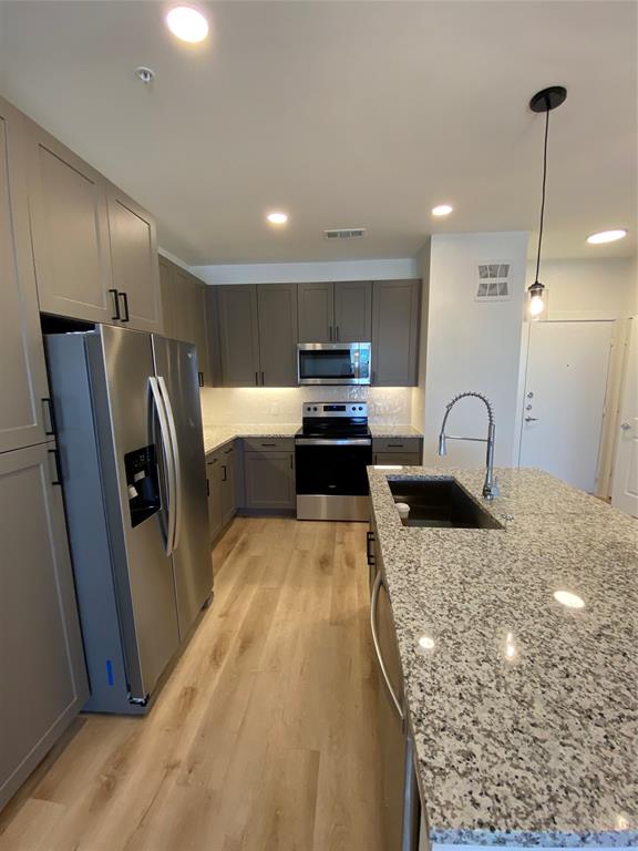 a large kitchen with sink refrigerator and cabinets