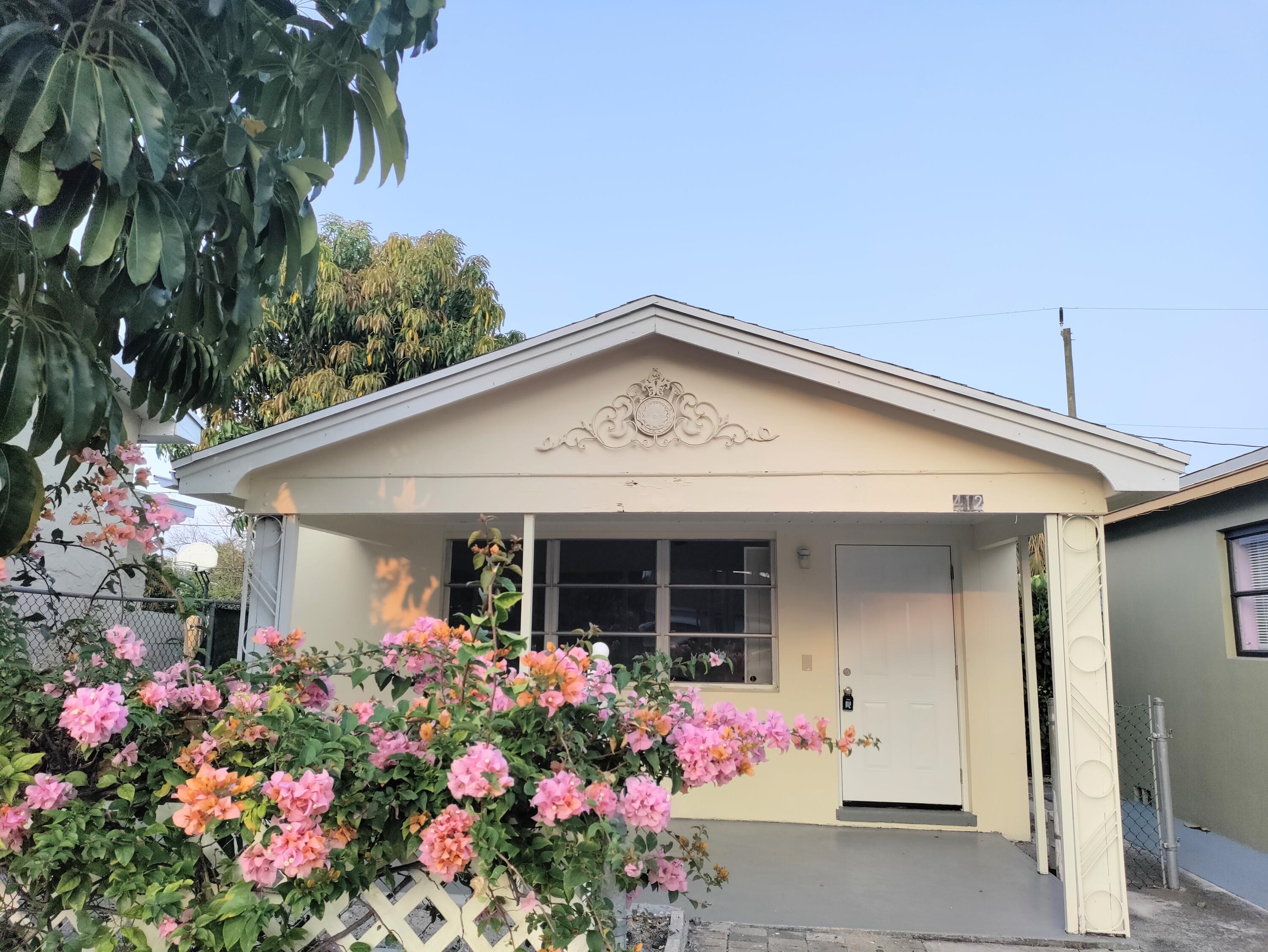 a front view of small house with flowers