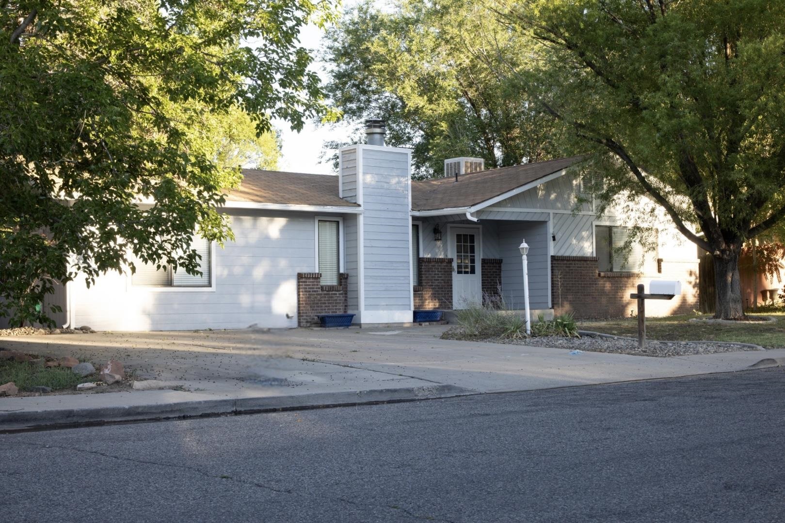 a front view of a house with yard and trees