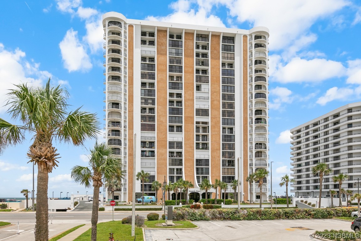 a front view of a building with palm trees