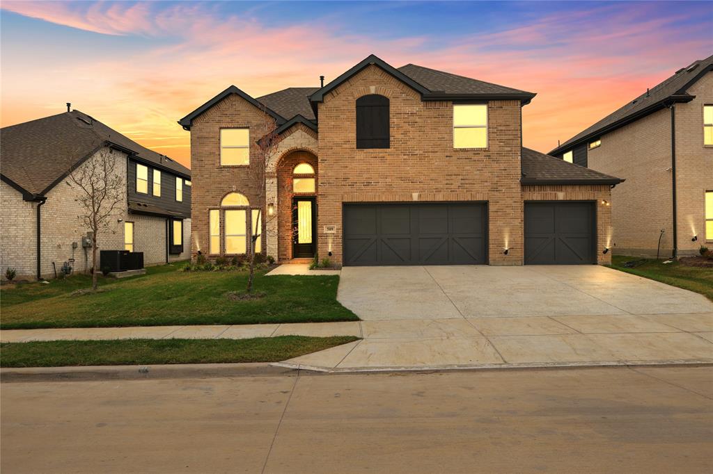 a front view of a house with a garden and garage