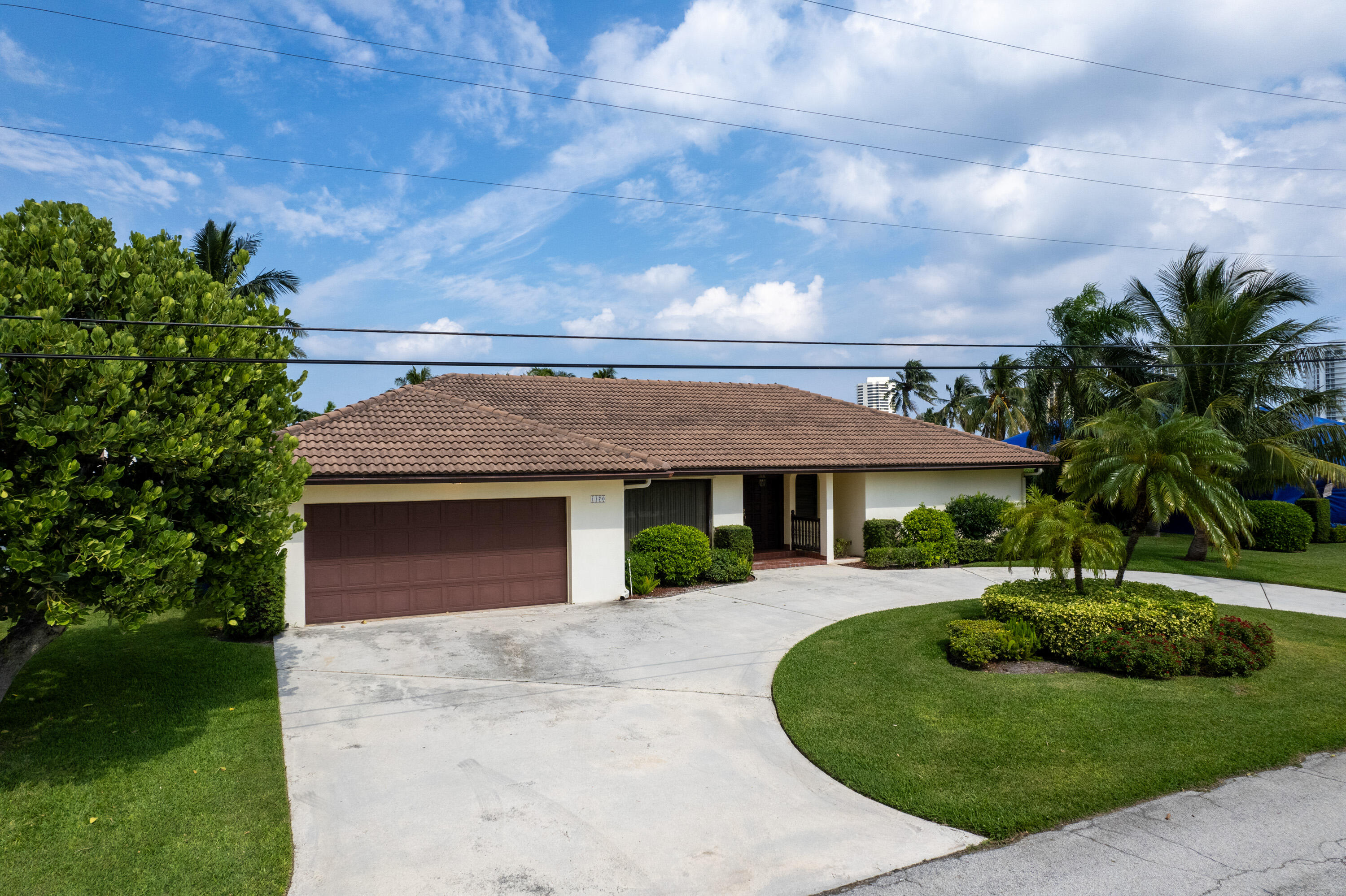 a front view of a house with a garden and trees