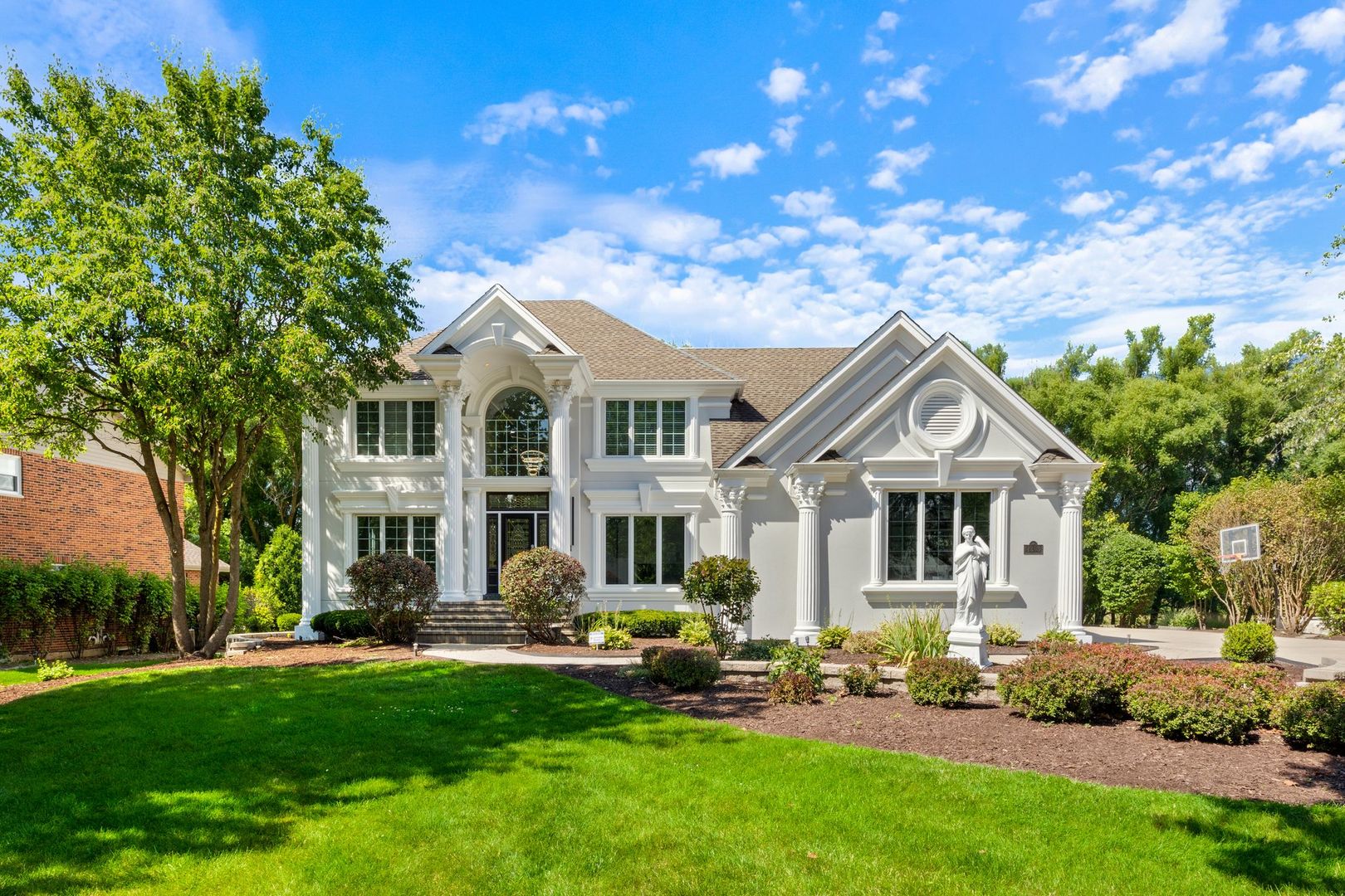 a front view of a house with a garden and plants