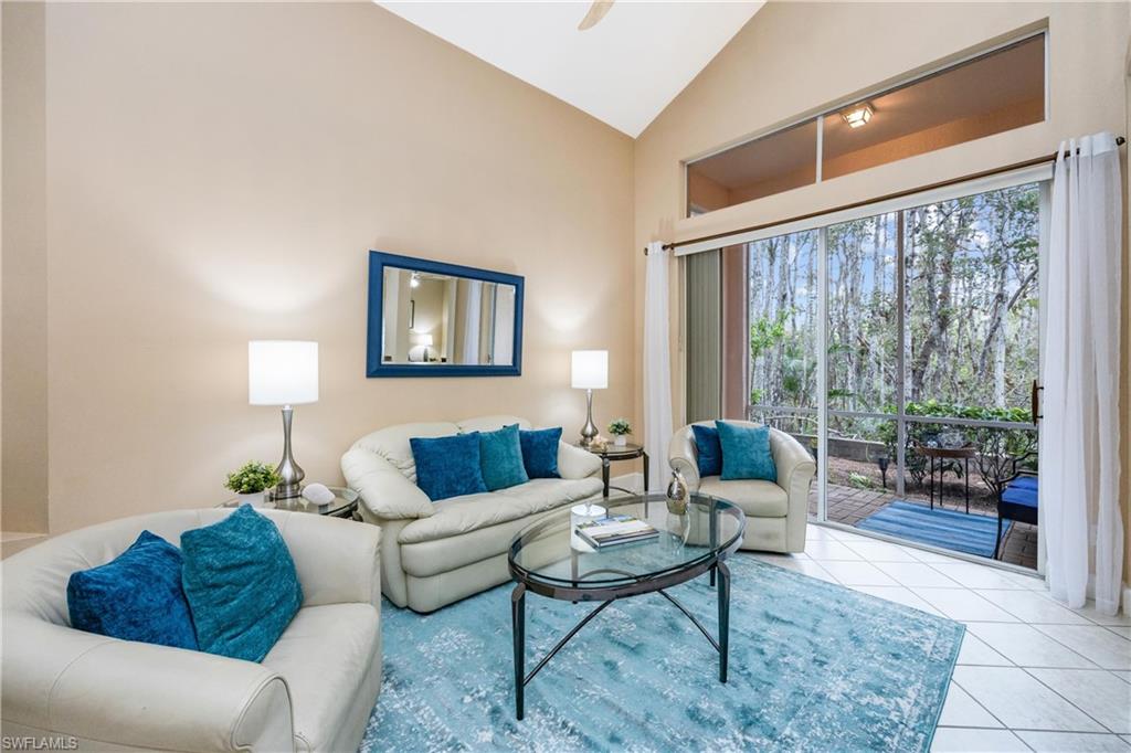 Living room featuring high vaulted ceiling and light tile patterned flooring