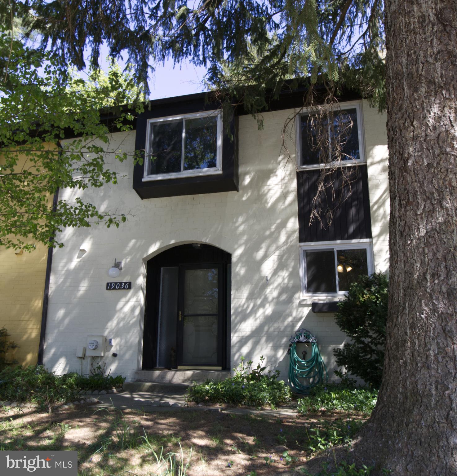 a front view of a house with plants