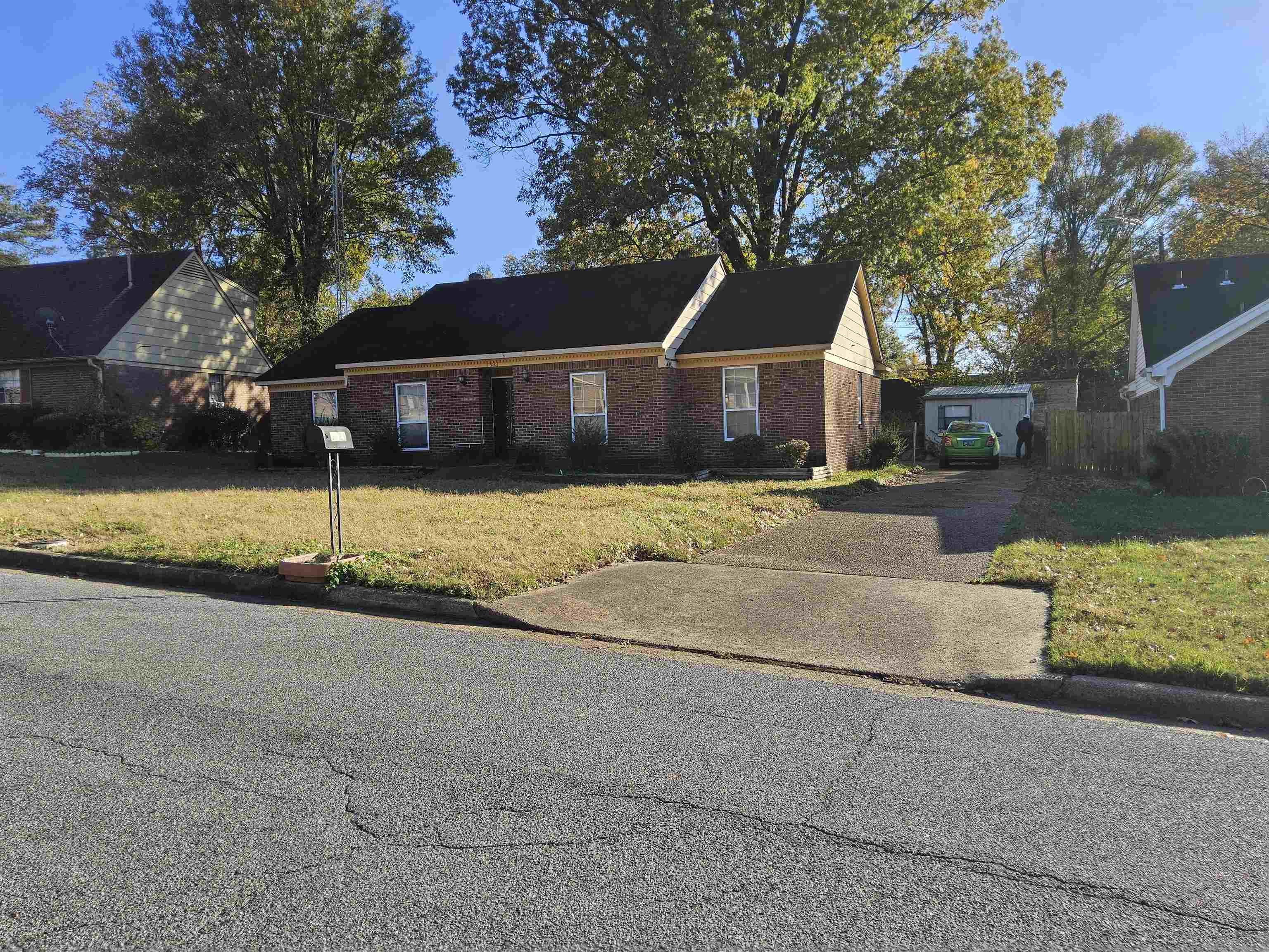 View of front of home with an outbuilding and a front lawn