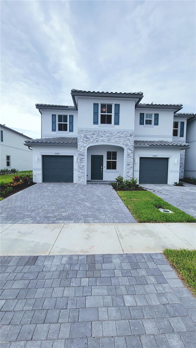 a front view of a house with a yard and garage