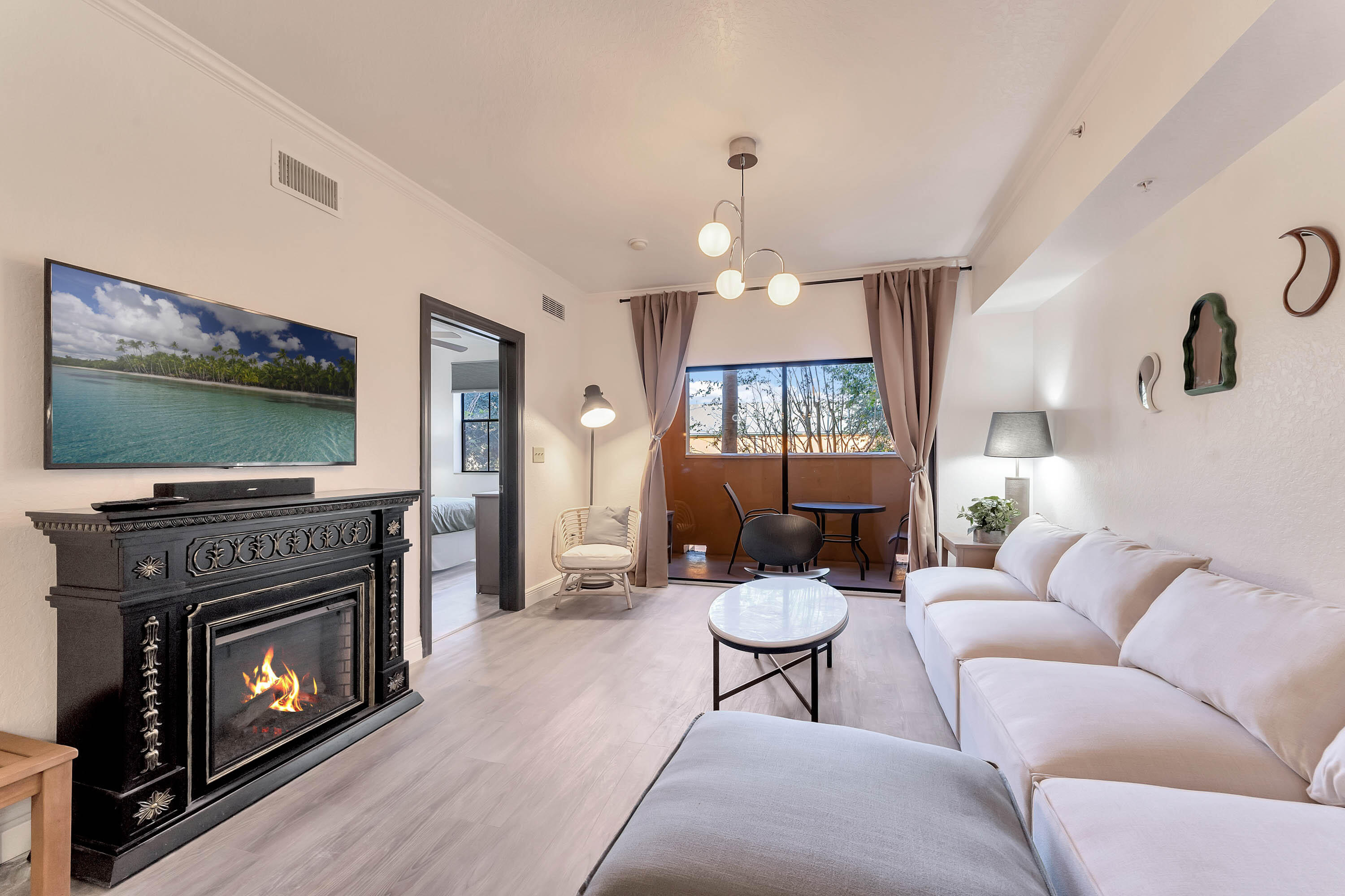 a living room with furniture a flat screen tv and a fireplace