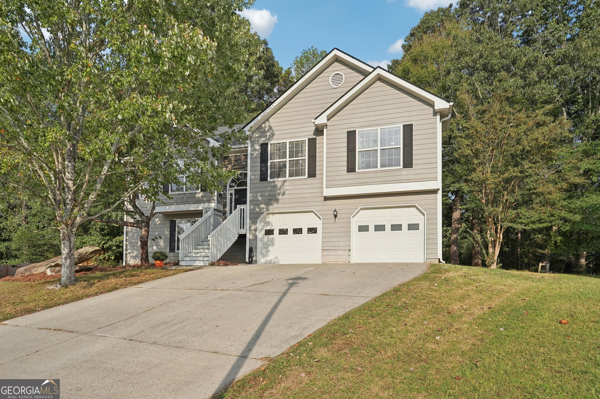 a view of house with yard and trees in the background