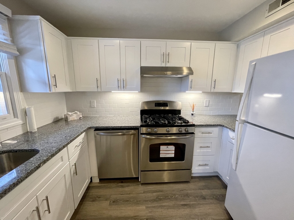 a kitchen with stainless steel appliances granite countertop a stove a sink and a refrigerator