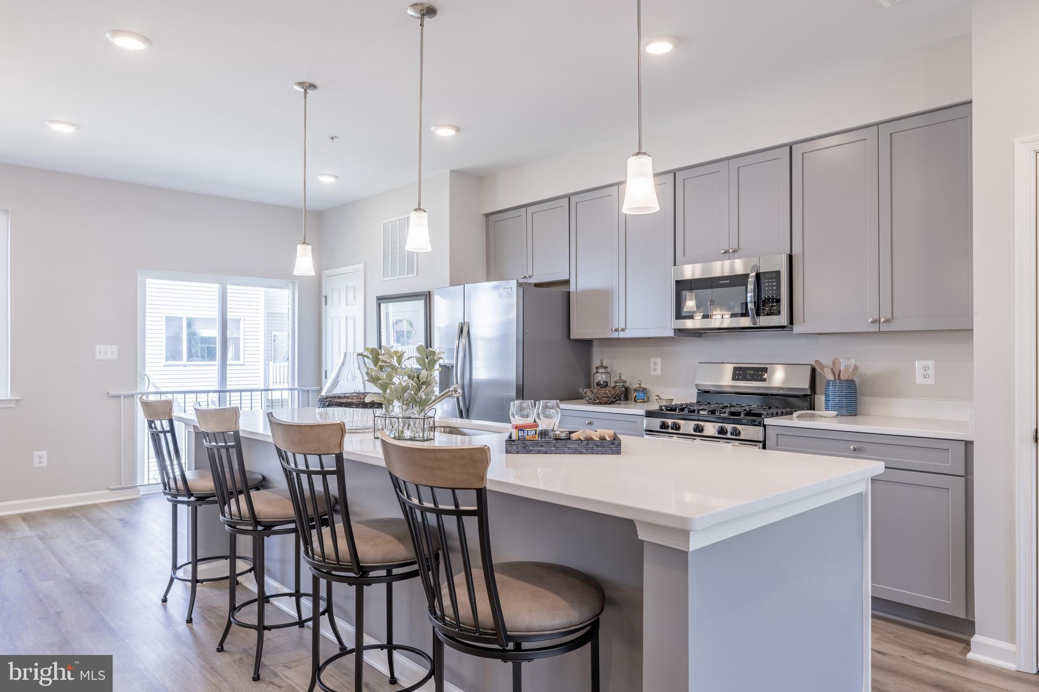 a kitchen with stainless steel appliances a white table and chairs in it