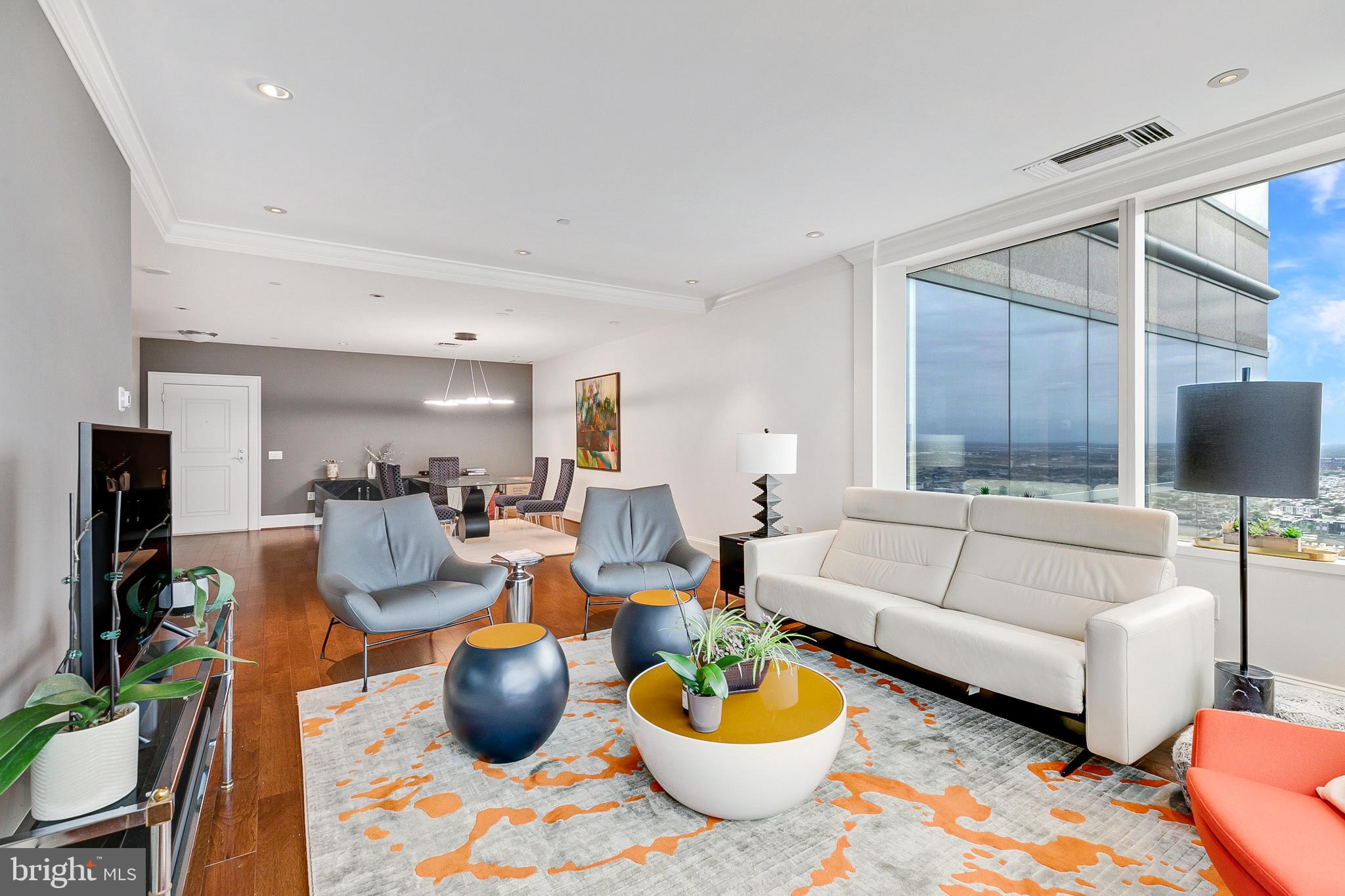 a living room with furniture a flat screen tv and a window