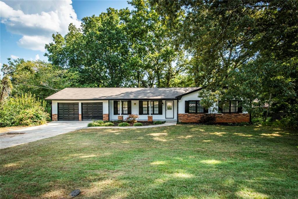 a view of a house with a yard deck and a large tree