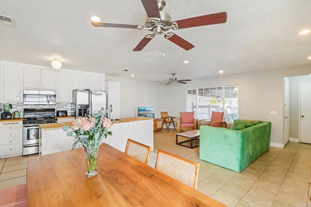 a living room with furniture kitchen view and a wooden floor