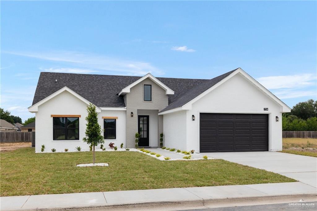 Modern farmhouse style home with a garage and a front lawn