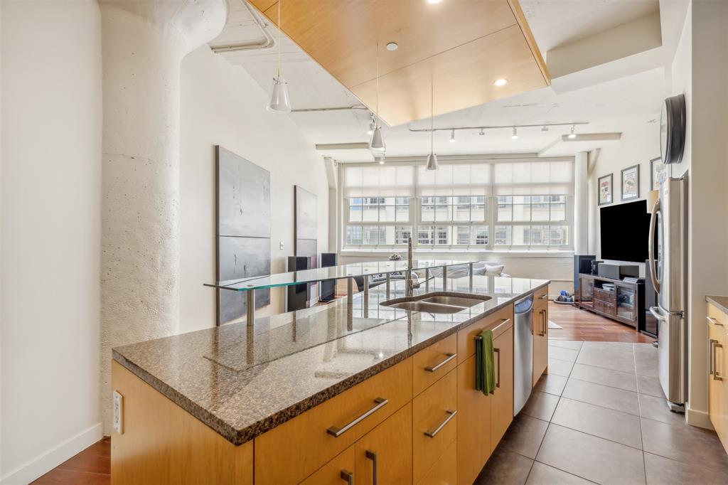 a kitchen with stainless steel appliances granite countertop a sink a stove and a refrigerator