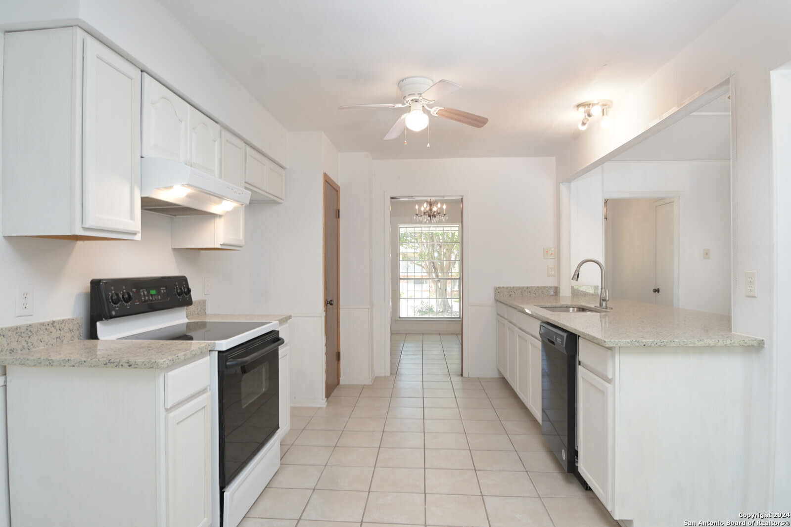 a kitchen with a sink dishwasher a stove and a refrigerator with wooden cabinets