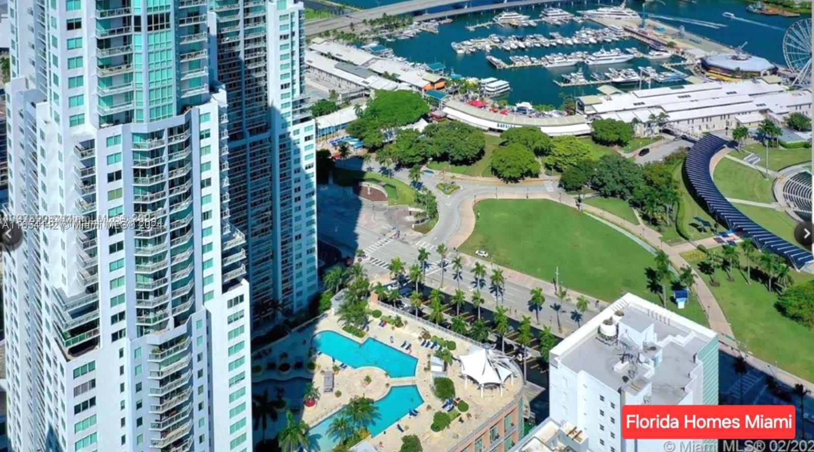 an aerial view of a residential apartment building with a yard and parking space