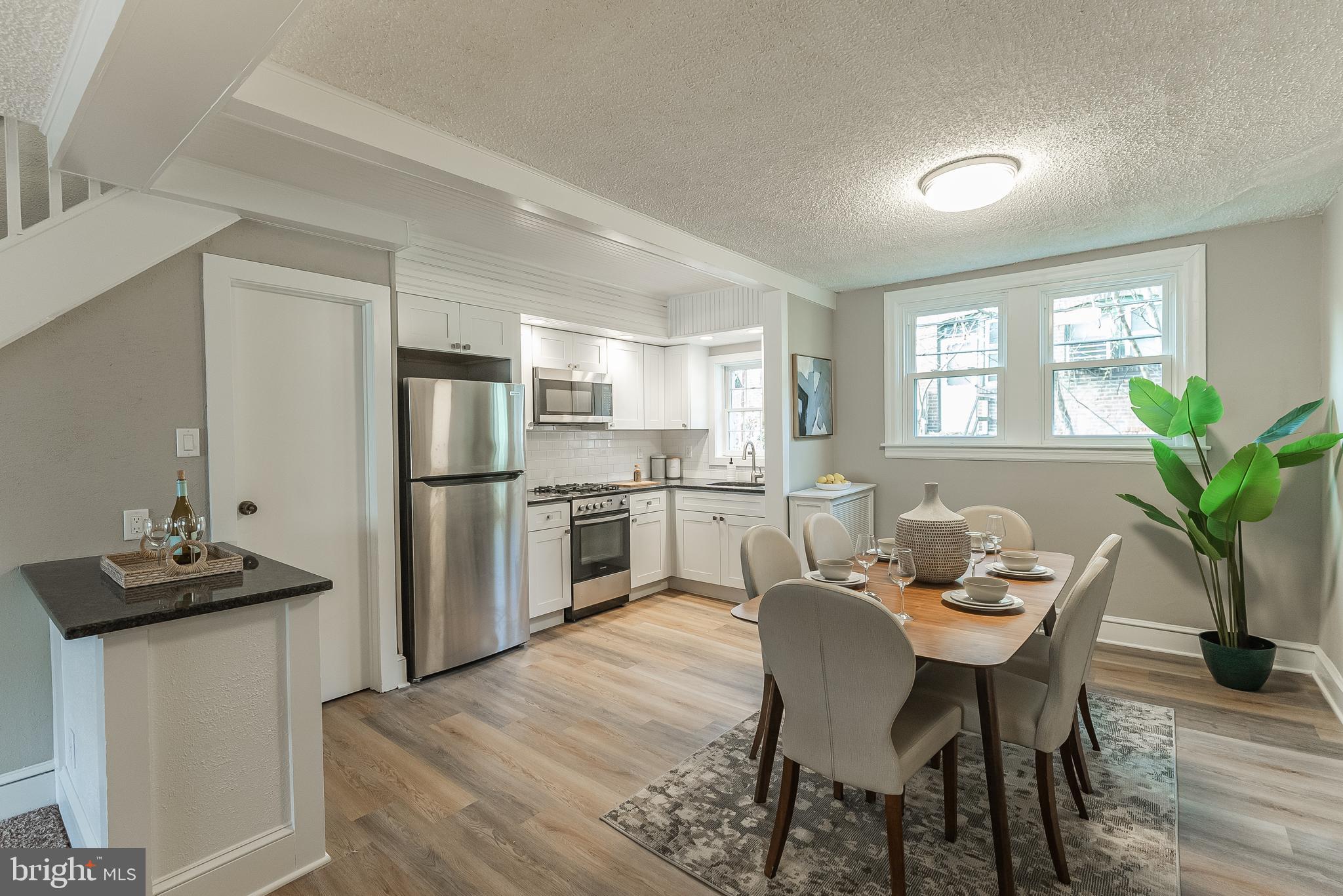 a kitchen with white cabinets and refrigerator