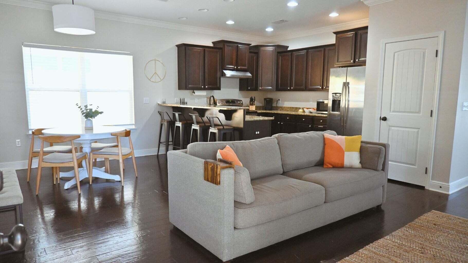 a living room with stainless steel appliances furniture and a kitchen view