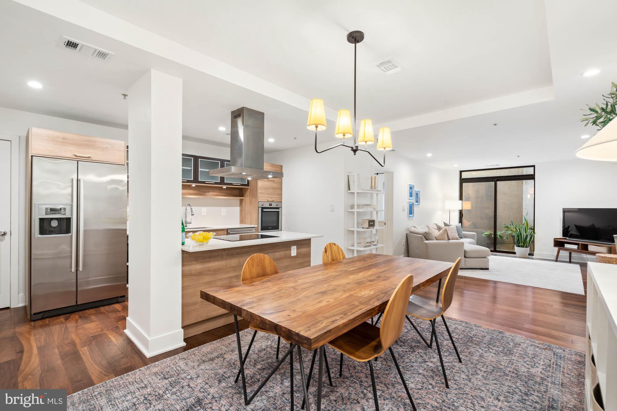 a view of a dining room and livingroom with furniture wooden floor a chandelier