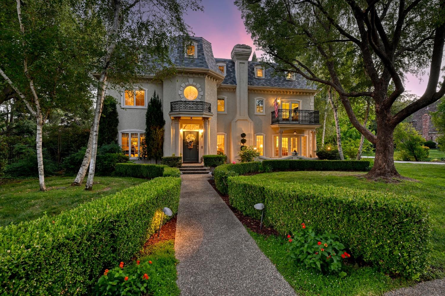 a front view of a house with a yard and potted plants