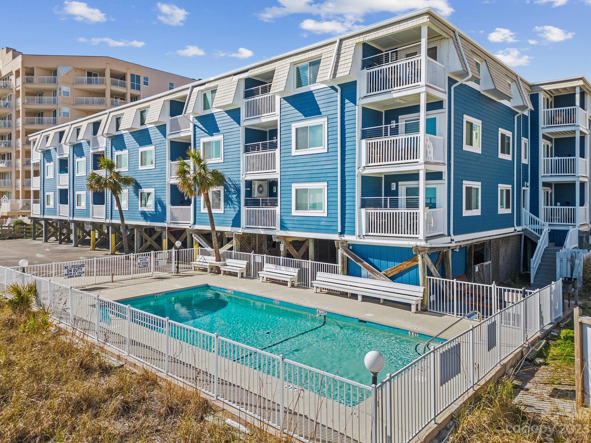 a view of building with a swimming pool and outdoor seating