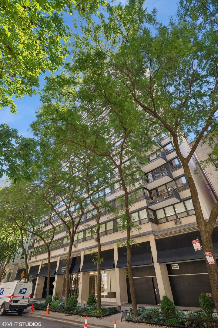 a front view of a building with lot of trees