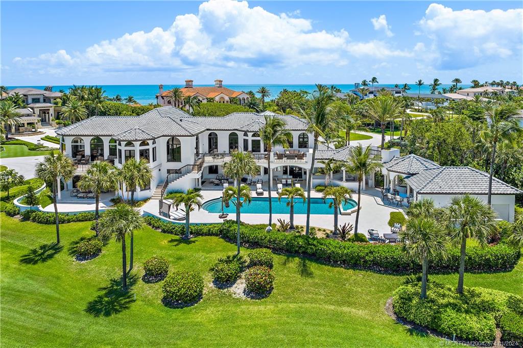 a view of a big house with a big yard and potted plants