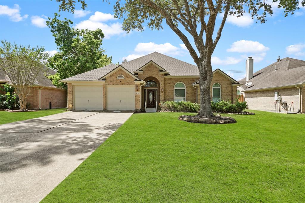 a front view of a house with a garden and trees