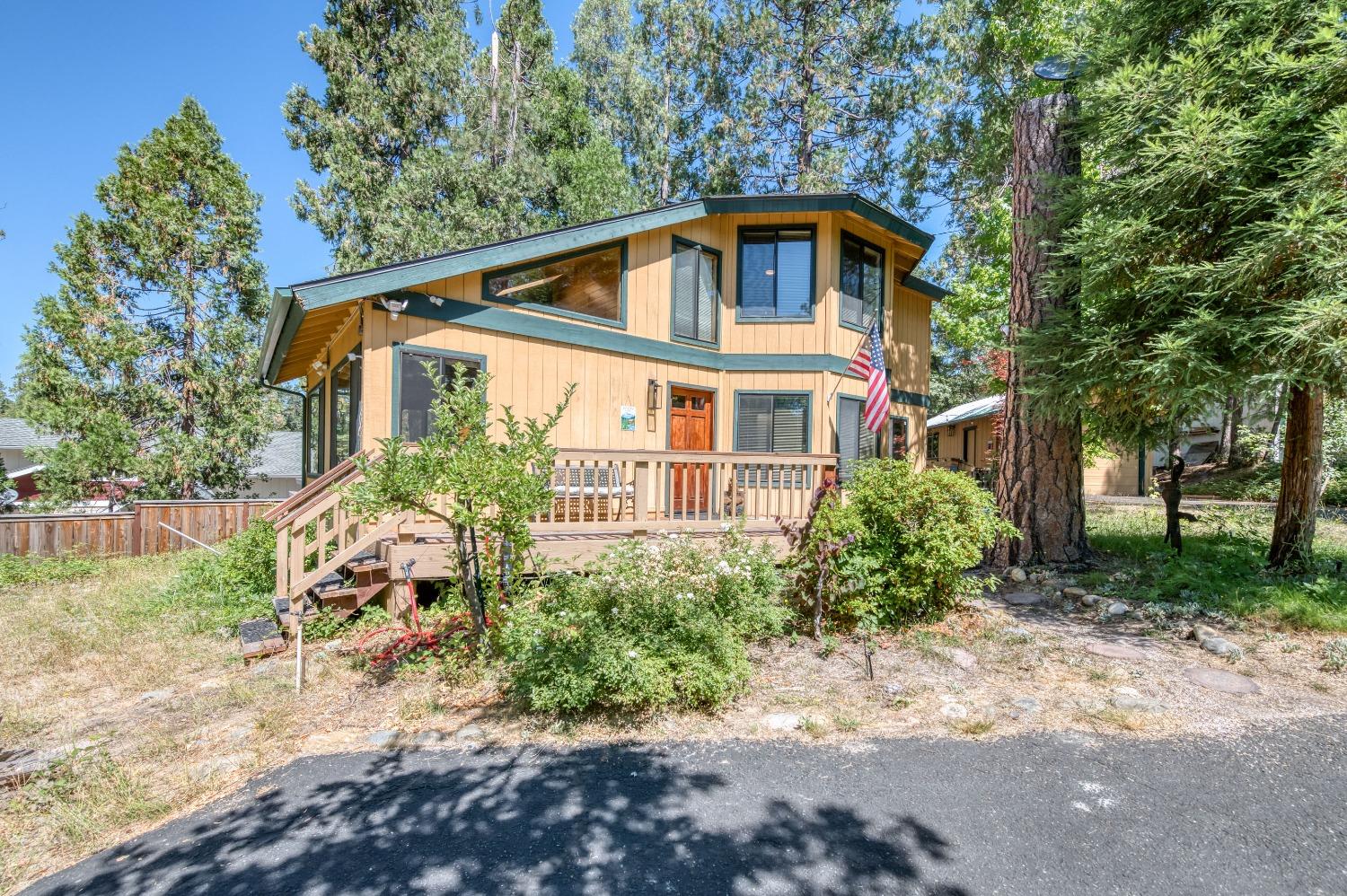 a front view of a house with a yard and trees