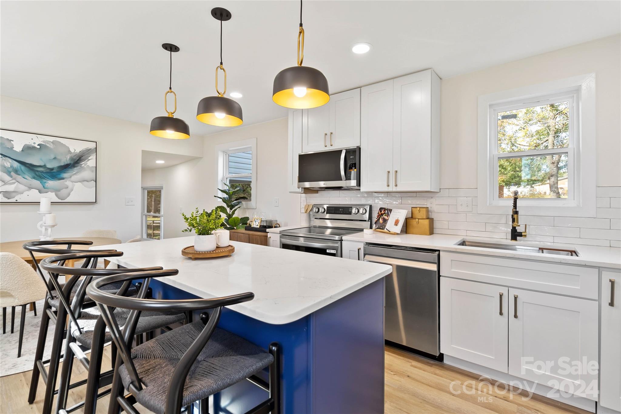 a kitchen with cabinets appliances and a dining table