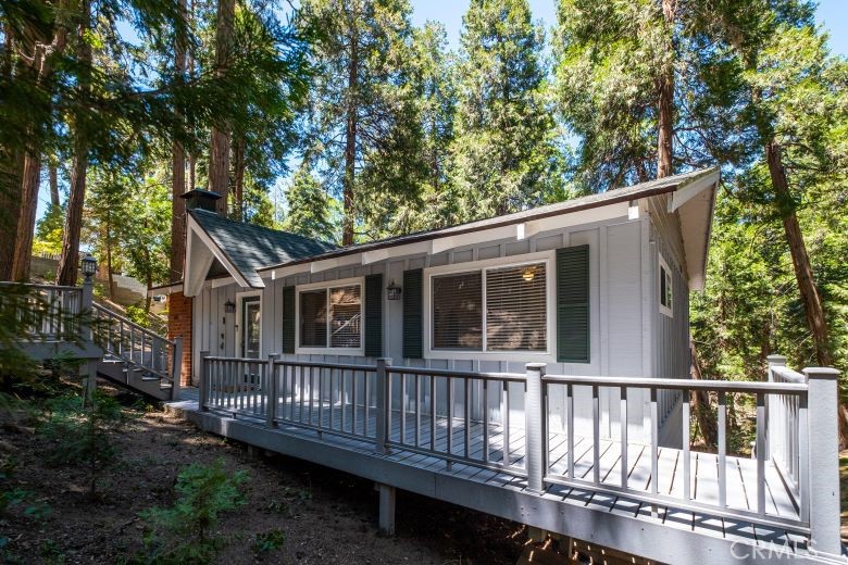 a view of a house with a wooden deck and a yard